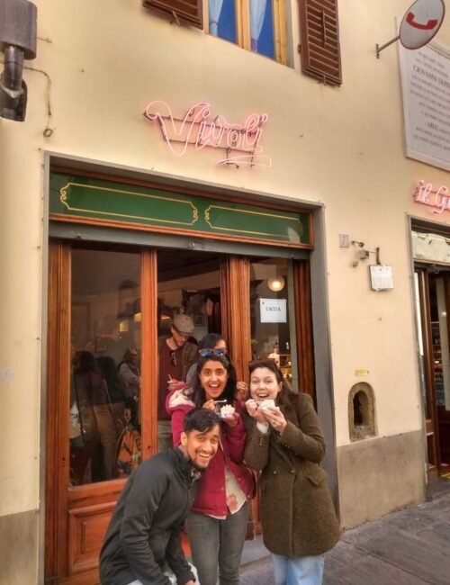 3 people eating gelatos in Italy and smiling at the camera